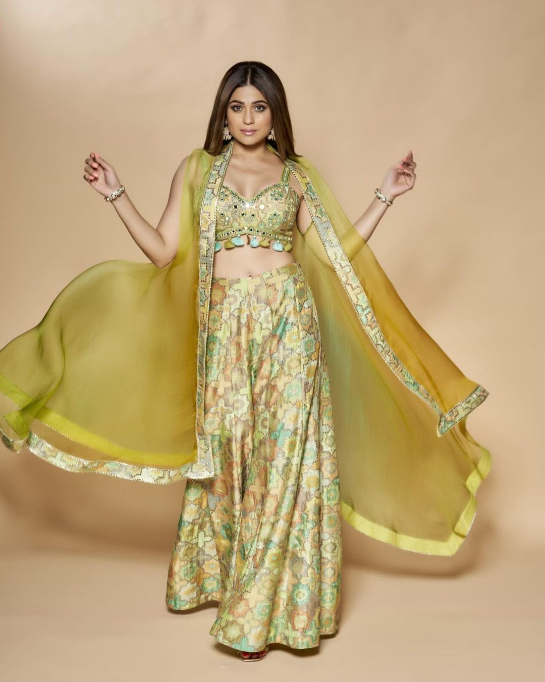 एक्ट्रेस ने इंस्टाग्राम अकाउंट पर अपनी तस्वीरें शेयर की हैं, जिसमें वह ग्रीन कलर के केप स्टाइल ड्रेस में बला की खूबसूरत लग रही हैं। ‘बिग बॉस’ फेम कंटेस्टेंट ने क्रॉप टॉप के साथ शरारा और एक केप वियर किया है, उन्होंने अपने लुक को झुमकों और कंगन से स्टाइल किया है।