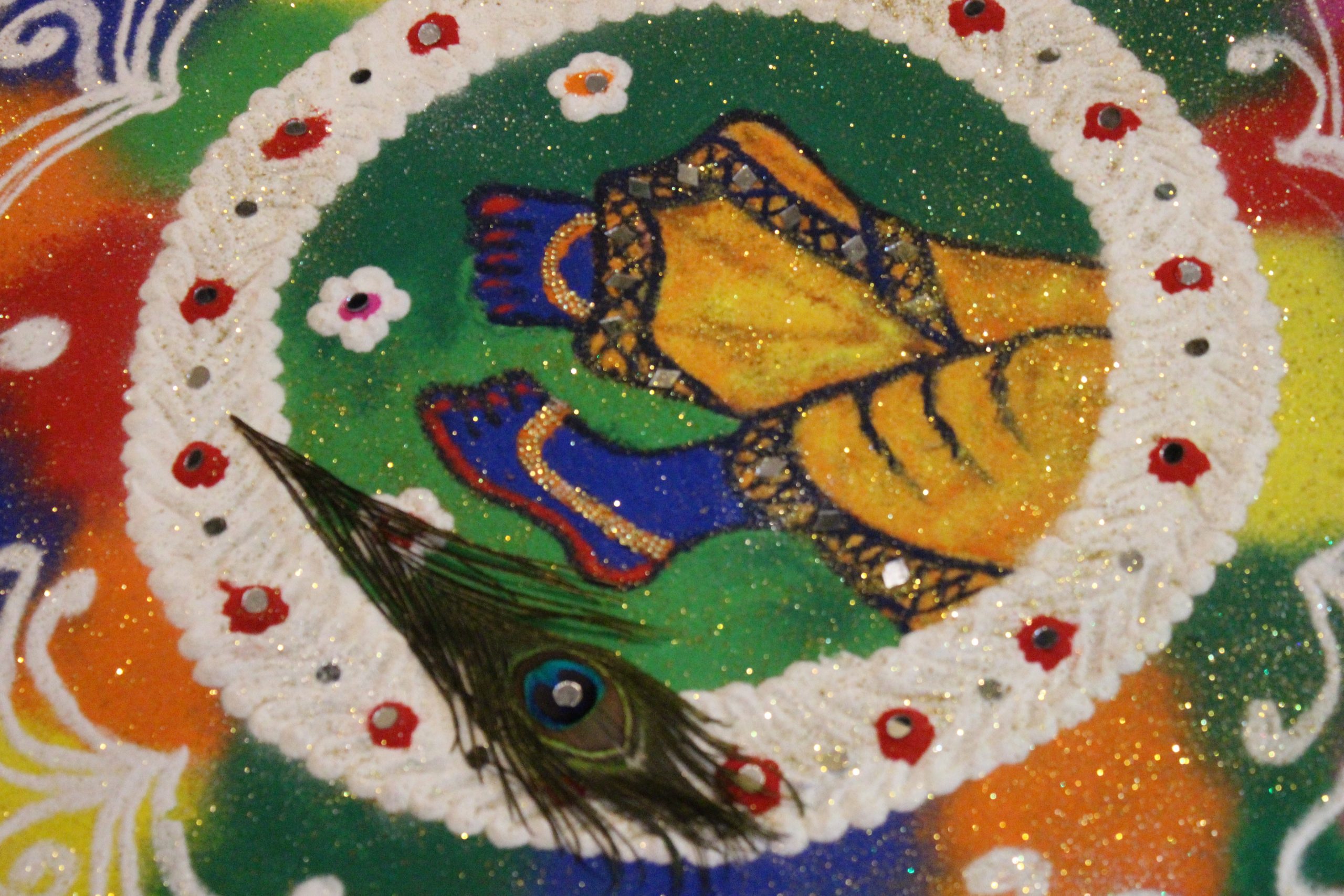 हैप्पी दिवाली कहती इस रंगोली को तैयार किया है पूजा, ममता और मोहिनी की ग्रुप ने। इस रंगोली में भगवान श्रीकृष्ण के चरणों को उकेरा गया है।