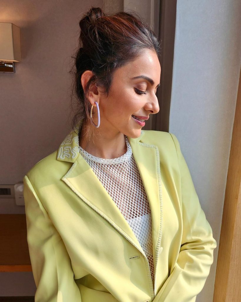 रकुल प्रीत ने इस लुक में येलो रंग की ड्रेस पहनी है और बालो को बंधे रखे है जिसमें रकुल बला सी खूबसूरत लग रही है लुक को कम्पलीट करने के लिए रकुल प्रीत ने राउंड एअरिंग और लाइट मेकअप का उसे किया है।