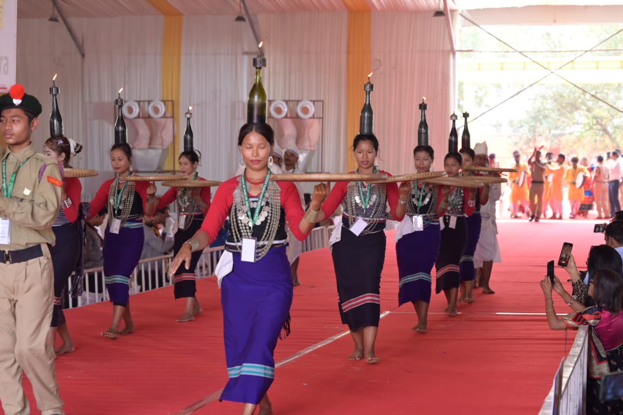त्रिपुरा का नर्तक दल सुन्दर प्रस्तुति देते हुए, अपने सिर पर चिमनी रख कर नृत्य करते हुए