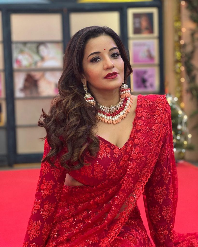 मोनालिसा ने अपने लुक को कंप्लीट करने के लिए रेड नेट वाली साड़ी के साथ फुल स्लीव्स वाला ब्लाउज, हैवी नेकलेस, बड़ी ईयरिंग्स, मरून लिपस्टिक और मेकअप किया है।