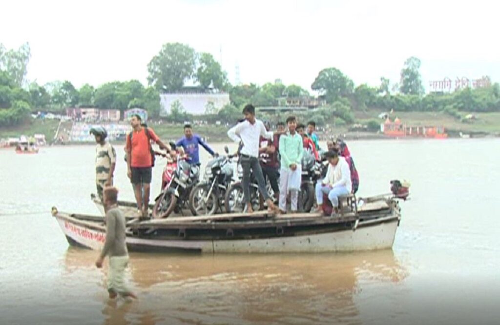 People risking their lives to travel on the surging waves of the Narmada River