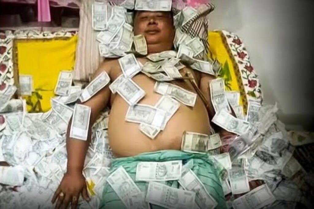 Benjamin Basumatary lying on a bed of 500 rupee notes